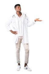 Wall Mural - Full body of African american doctor holding copyspace imaginary on the palm to insert an ad on white background