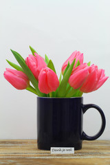 Wall Mural - Dank je wel (thank you in Dutch) card with mug full of Dutch pink tulips on wooden surface
