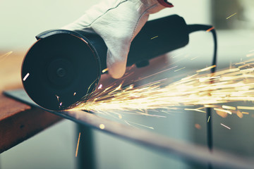 Worker grinding a metal plate