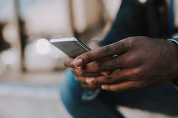 Close up of a modern mobile phone used by an afro american young man