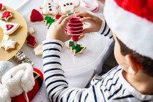 Little Kid Decorating Christmas Biscuits At Christmas Day