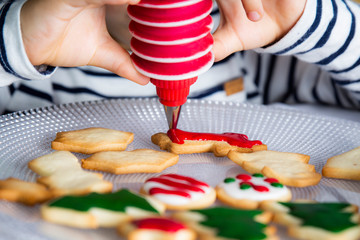 Wall Mural - Little kid decorating Christmas biscuits at Christmas day