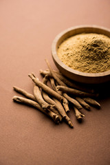 Wall Mural - Ashwagandha / Aswaganda OR Indian Ginseng is an Ayurveda medicine in stem and powder form. Isolated on plain background. selective focus