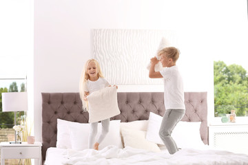 Poster - Happy children having pillow fight on bed at home