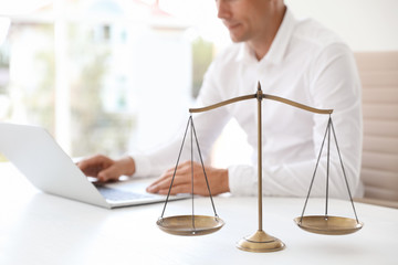 Wall Mural - Scales of justice and blurred notary with laptop on background