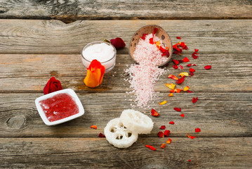 facial mask and moisturizer with roses on weathered wooden