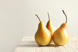 Ripe pears on wooden table against light background. Space for text