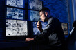 © New Africa - Male security guard with portable transmitter monitoring modern CCTV cameras indoors