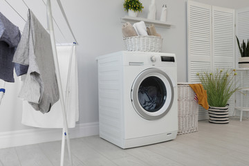 Poster - Laundry room interior with washing machine near wall