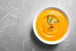 © New Africa - Bowl of tasty pumpkin soup and space for text on gray table, top view