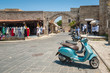 Street view. Scooter parked in front of the remains of the Church of the Virgin of the Burgh. Rhodes, Old Town, Island of Rhodes, Greece, Europe.