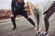 Young woman tying her shoes before jogging with her boyfriend