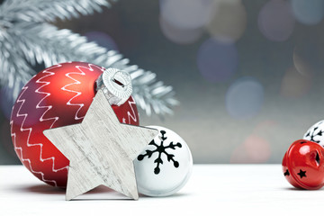 Wall Mural - christmas tree decorations on grey background with blurred silver fir tree branch and light spots