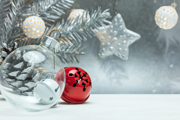 christmas tree decorations on blurred silver background with fir tree branch and retro garlands