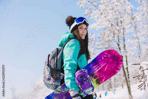 Fototapeta na szkło Wypoczynek, zima, sport koncepcja - osoba snowboardzista idzie z wyżywieniem