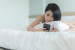 © SHUTTER DIN - woman with phone in bedroom