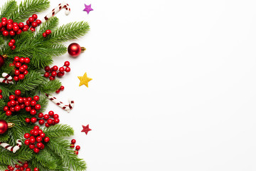 christmas and new year's composition. top view of spruce branches, pine cones, red berries and bell 