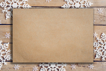 Wooden brown christmas background with snowflakes and old brown paper with space.