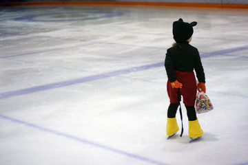 costumed child on ice skates with pack of candy