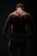 © Vladimir - Muscular man with a powerful back posing on a black background. concept of sports and fitness