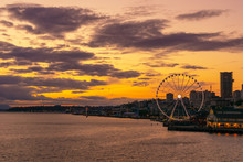 Vibrant And Colorful Seattle Skyline Waterfont With The Great Or Ferris Wheel At Sunset Or Dusk From Elliott Bay, Washington State, USA.