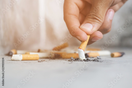 Hand Putting Out A Cigarette Cigarette Butt On Concrete Floor