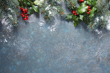 Wall Mural - christmas background with fir tree and holly berry, covered in snow, with copy space.