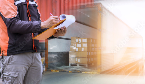 Cuadros en Lienzo warehouse loader are holding a clipboard with inspect loading the shipment into a truck