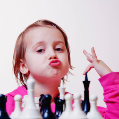 Young beautiful caucasian child girl playing a game of chess. (Development, learning, childhood, wunderkind concept)