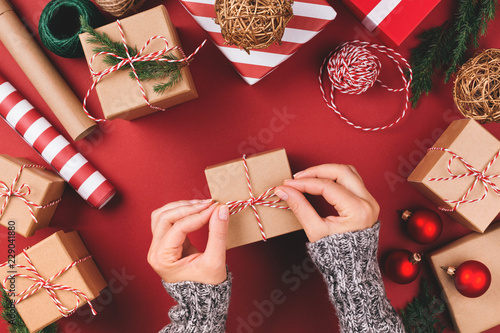 Christmas background with gift boxes, clews of rope, paper's rools and decora...
