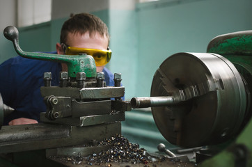 Wall Mural - Turner worker is working on a lathe machine in a factory.