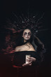 © oes - Terrible horror Halloween Vampire Woman portrait. Beauty Vampire Witch lady with blood on mouth posing in deep forest. Fashion Art design. holds a candle in his hands and reads curses