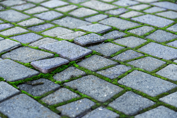 Damaged asphalt road with potholes, caused by freeze-thaw cycles in winter. Bad road. Broken pavements sidewalks on sidewalk. pavement with paving slabs with defects and cracks coming in perspective