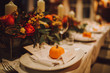 © Olga - Thanksgiving table setting with automnal decorations, pumpkins, glasses and plates. Holidays, catering and hospitality concept.