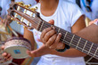 Detail of guitarist's hands and his acoustic guitar at an outdoor samba presentation