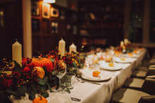 Thanksgiving Table Setting With Automnal Decorations, Pumpkins, Glasses And Plates. Holidays, Catering And Hospitality Concept.