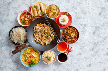 Asian oriental food composition in colorful dishware, served on stone, top view. Chinese, vietnamese, thai cuisine set. With copy space