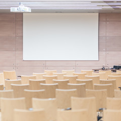 view of empty wooden seats in a modrn lecture hall.