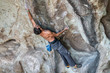 © abriendomundo - The last movements to reach the summit by a male climber. Rock climbing inside the Andes mountains at Cajon del Maipo, Chile. Climber solving the movements of 'Annunaki' route a 8b french difficulty
