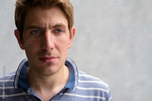 Portrait Of Handsome Man With Blond Hair Against Concrete Wall