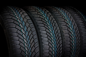  Winter car tires in row isolated on black