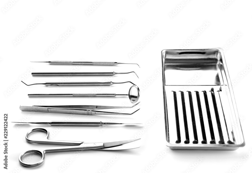 Dentist's tools and metal tray on white background