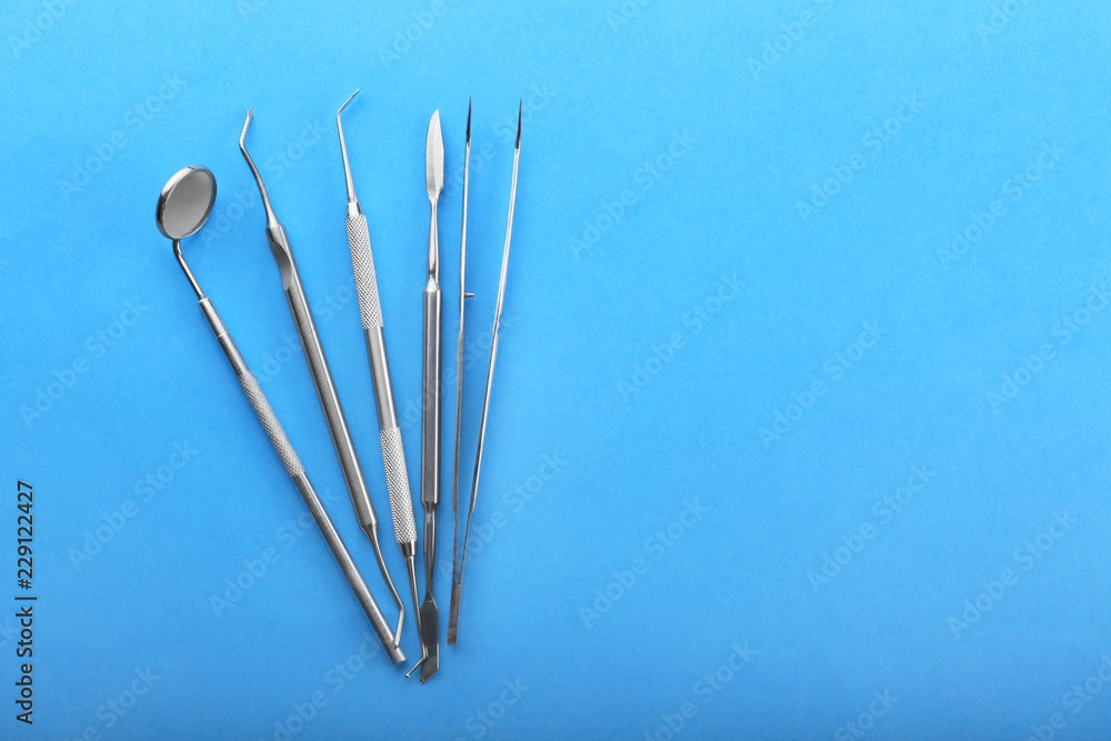 Dentist's tools on color background