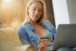© goodluz - Blond woman at home shopping online