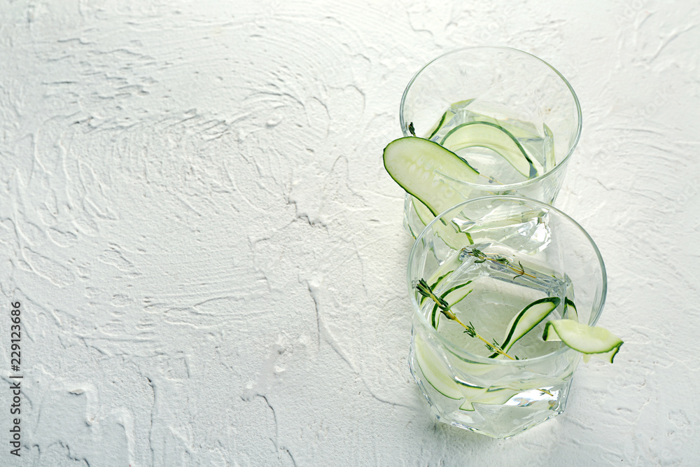 Glasses of fresh cucumber water on white table