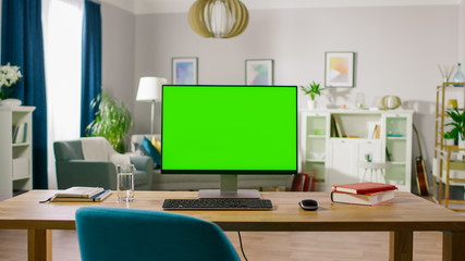 Modern Personal Computer with Mock-up Green Screen Display Standing on the Desk of the Cozy Home Office. Living Room of Stylish Interior Designer.