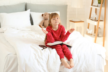 Canvas Print - Little girl with Bible praying in bedroom