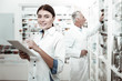 © Viacheslav Yakobchuk - Female pharmacist. Beaming blue-eyed appealing dark-haired female pharmacist wearing white coat feeling cheerful