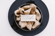 © Joske - A handwritten place card on a bed of silk ribbon as part of a wedding table setting.