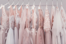New Design. Wedding Dresses Hanging Together In The Wedding Boutique While Waiting For Someone To Buy Them